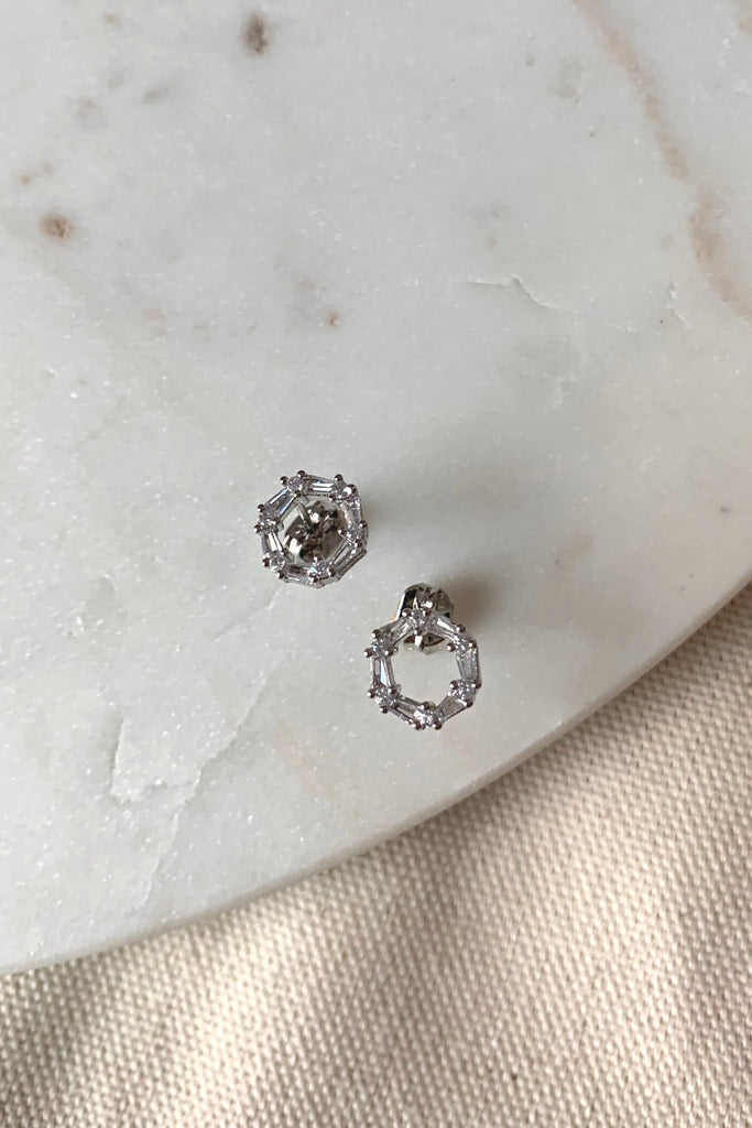 Adorn your ears with the timeless sophistication of this dainty open circle stud. Crafted from 14K gold dipped metal and featuring a radiant crystal cut-out center, this piece is eye-catching and hypoallergenic. A perfect accessory for any outfit.