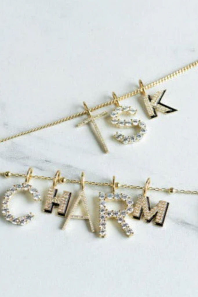 Personalize your look with the Sis Kiss Charm Bar! These sleek initials are so fun and add little flare to you look. Choose between gold or silver. Layer up with our other charms for an extra fun necklace. 