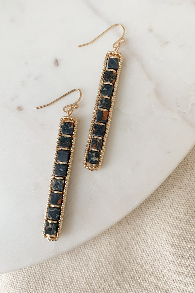 The 2" Semi Precious Stone Long Bar Earrings are super elevated and unique. We love the natural stone combined with gold bead details. This earring is a fun statement for fall. 