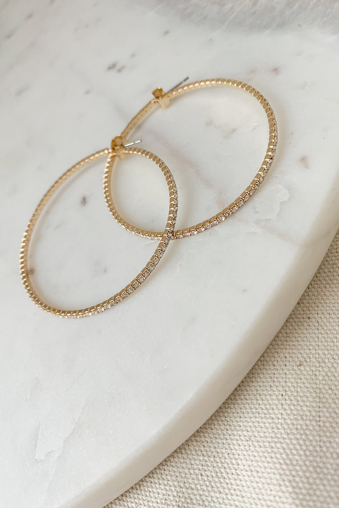 The 50MM Gold Crystal Hoop Earrings are so stunning. Because they are a thin hoop, they are very lightweight and comfortable. You will be surprised how great they feel. Plus, the extra sparkle looks so nice, easily dressing up any outfit. 