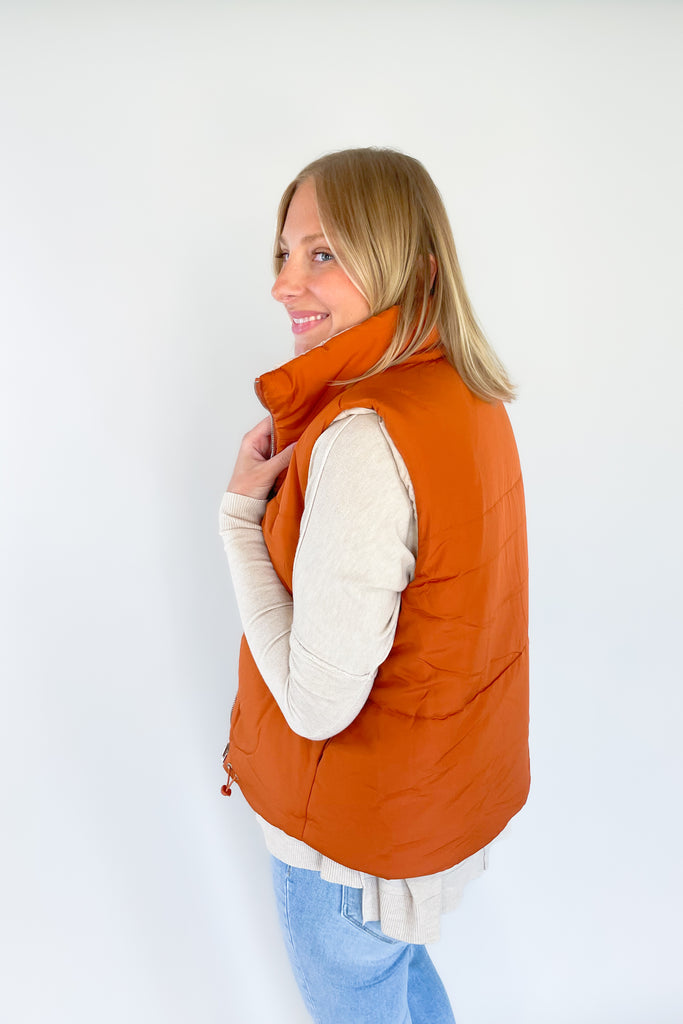 This stylish Beige + Orange Reversible Puff Vest is a great way to stay warm without sacrificing your sense of style. It comes in a beige and orange color that's eye-catching. It features a zip-up front, side pockets, and an adjustable drawstring at the bottom for a perfect fit.