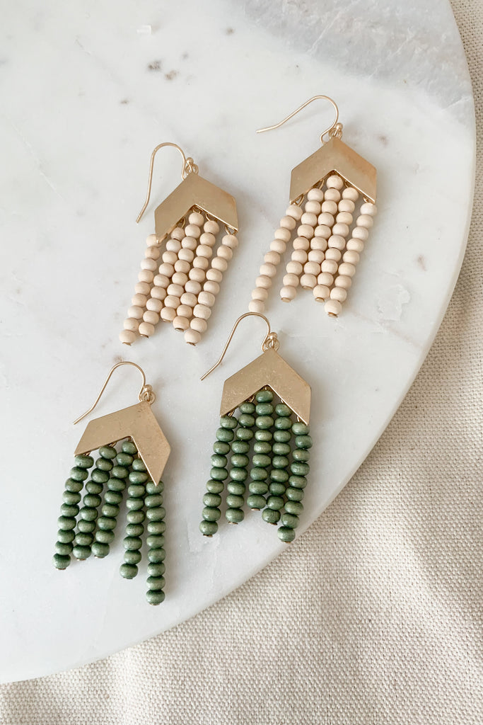 The Chevron Wood Bead Drop Tassel Earrings are unique with a touch of boho, especially with hammered metal and beaded details. These earrings will elevate any everyday look. Choose between ivory or green. 