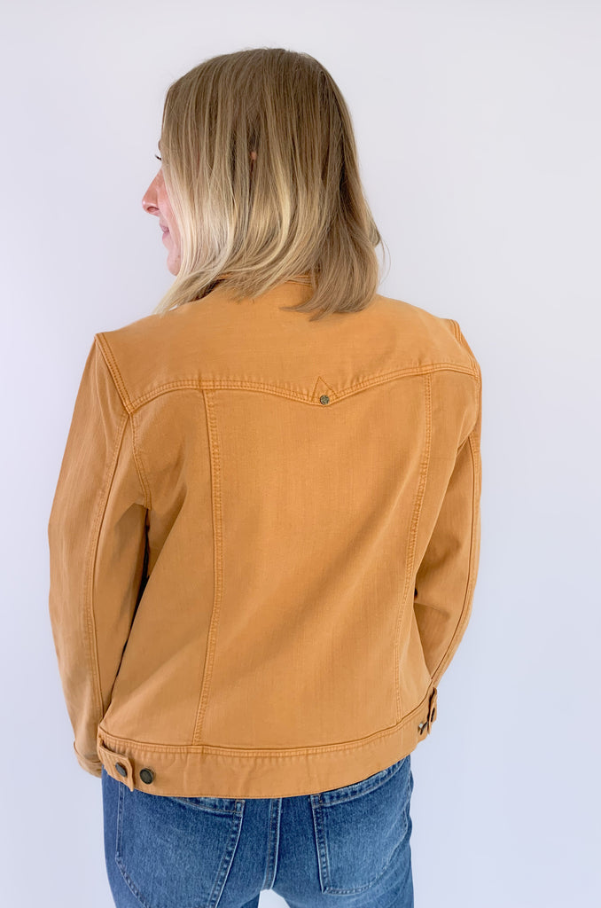 The Liverpool Los Angeles Classic Amber Dawn Jean Jacket is perfect for fall! The color is a unique cross between a burnt mustard and orange. With amazing stretch and recovery, this classic jean jacket will be your new go-to layering piece. It adds a unique touch to any look and a little pop of color.