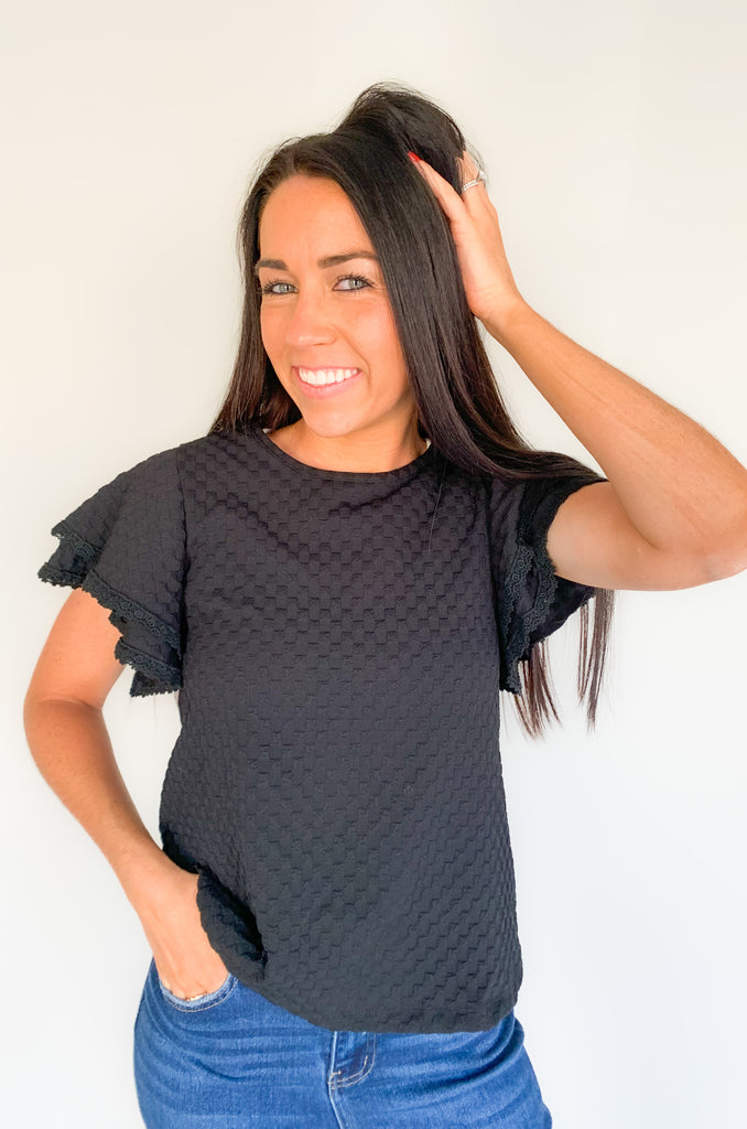  Our Daily Double Ruffle Textured Short Sleeve Blouse adds a chic touch to any wardrobe. Enjoy a sweet ruffle sleeve, a delicate lace trim on the ruffles, and a modern checkered pattern to give this blouse an elegant look! Perfect to be worn alone or under a blazer for a more formal look! 