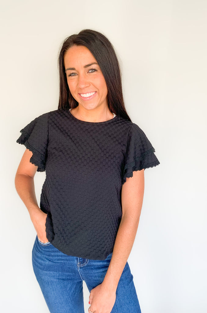  Our Daily Double Ruffle Textured Short Sleeve Blouse adds a chic touch to any wardrobe. Enjoy a sweet ruffle sleeve, a delicate lace trim on the ruffles, and a modern checkered pattern to give this blouse an elegant look! Perfect to be worn alone or under a blazer for a more formal look! 