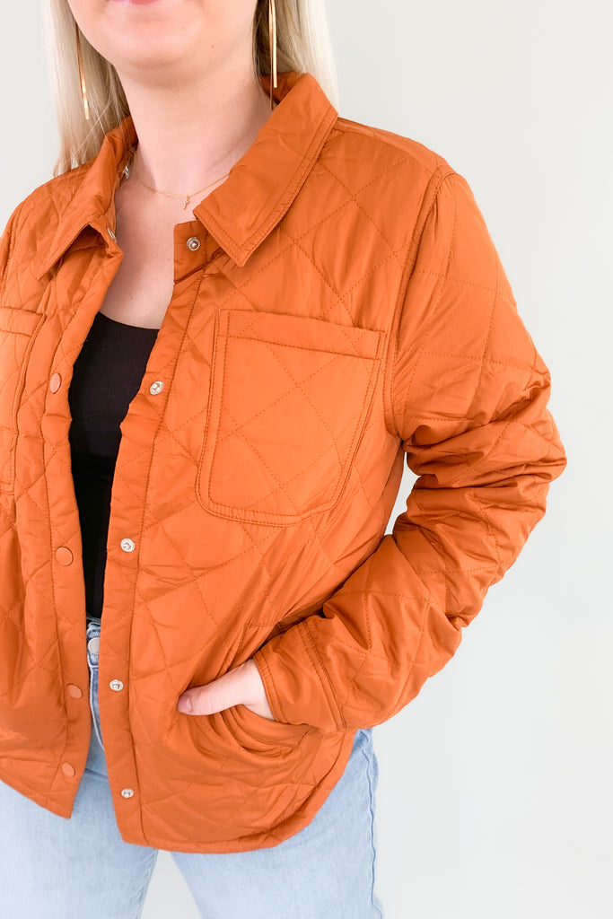 Orange quilted puffer jacket with snap buttons
