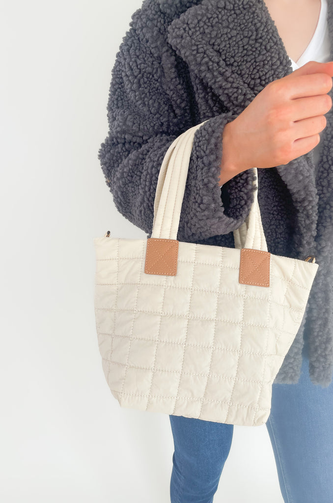 The Ezra Mini Tote Crossbody is perfect for on the go! The quilted design is right on trend while also being lightweight and elevated. It also washes easily- a major win! These bags come with a detachable fabric shoulder straps and faux leather details. On the inside, there are multiple pockets for storage and a zip enclosure. Choose between ivory, camel, or green to complete your look! 