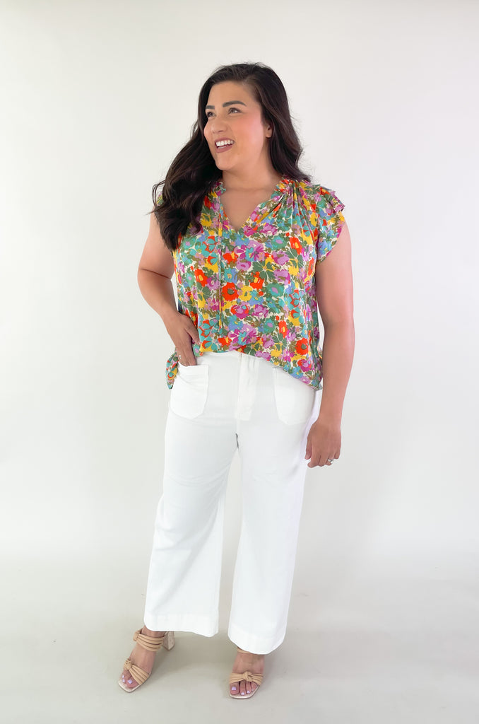 This Feel Good Floral Ruffle Sleeve Blouse is perfect for days when you want to feel your best! It's vibrant and designed for fun. Crafted with a lightweight fabric, it feels great in this summer heat. This blouse has beautiful ruffle cap sleeves, a v neck design, and a vibrant floral print that adds a pop of color to any look!