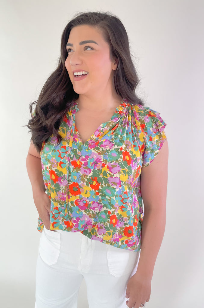This Feel Good Floral Ruffle Sleeve Blouse is perfect for days when you want to feel your best! It's vibrant and designed for fun. Crafted with a lightweight fabric, it feels great in this summer heat. This blouse has beautiful ruffle cap sleeves, a v neck design, and a vibrant floral print that adds a pop of color to any look!