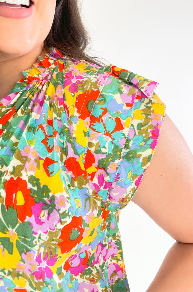 This Feel Good Floral Ruffle Sleeve Blouse is perfect for days when you want to feel your best! It's vibrant and designed for fun. Crafted with a lightweight fabric, it feels great in this summer heat. This blouse has beautiful ruffle cap sleeves, a v neck design, and a vibrant floral print that adds a pop of color to any look!
