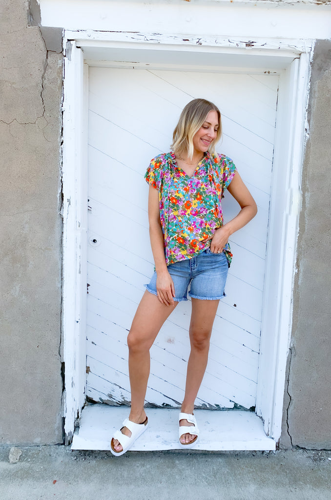 This Feel Good Floral Ruffle Sleeve Blouse is perfect for days when you want to feel your best! It's vibrant and designed for fun. Crafted with a lightweight fabric, it feels great in this summer heat. This blouse has beautiful ruffle cap sleeves, a v neck design, and a vibrant floral print that adds a pop of color to any look!