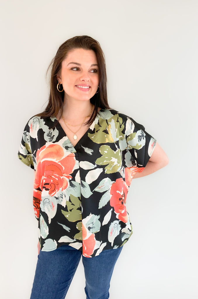 Beautifully crafted from a luxurious silk-like fabric, the Flounce Floral Loose Fit V Neck is a perfect addition to any wardrobe. It is very wear now, but also transitions well into the fall. Featuring a vibrant teal, olive, and blush floral print against a classic black backdrop, this flowy, oversized blouse provides both comfort and style. 