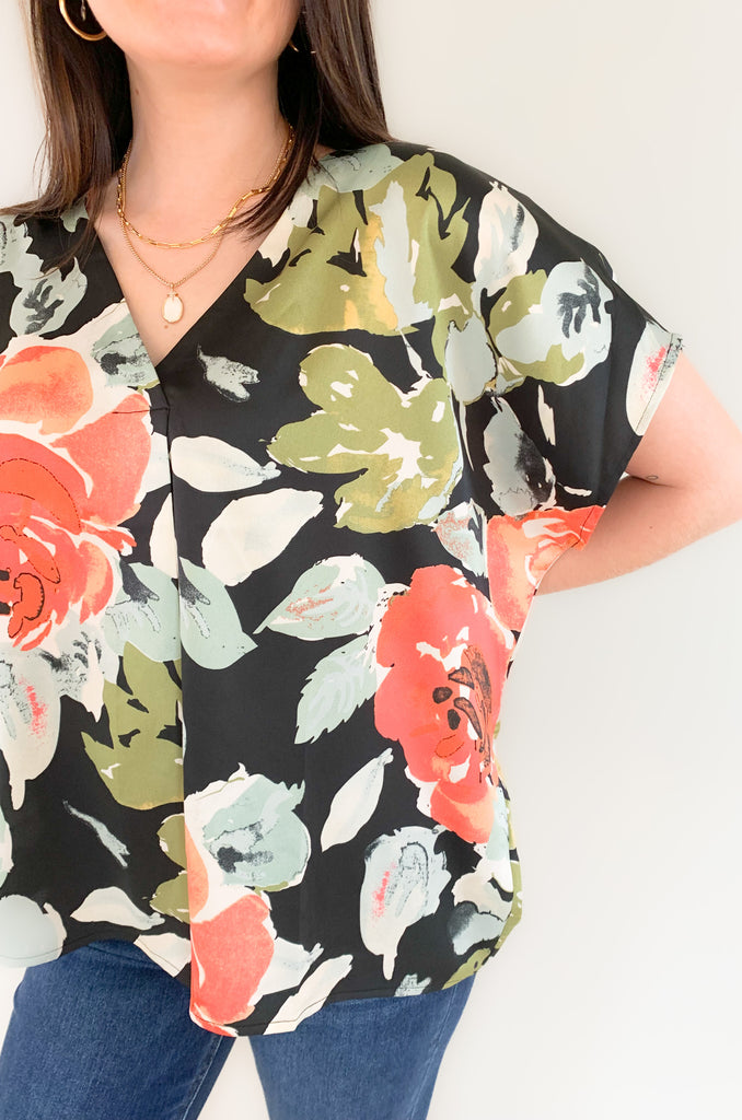 Beautifully crafted from a luxurious silk-like fabric, the Flounce Floral Loose Fit V Neck is a perfect addition to any wardrobe. It is very wear now, but also transitions well into the fall. Featuring a vibrant teal, olive, and blush floral print against a classic black backdrop, this flowy, oversized blouse provides both comfort and style. 