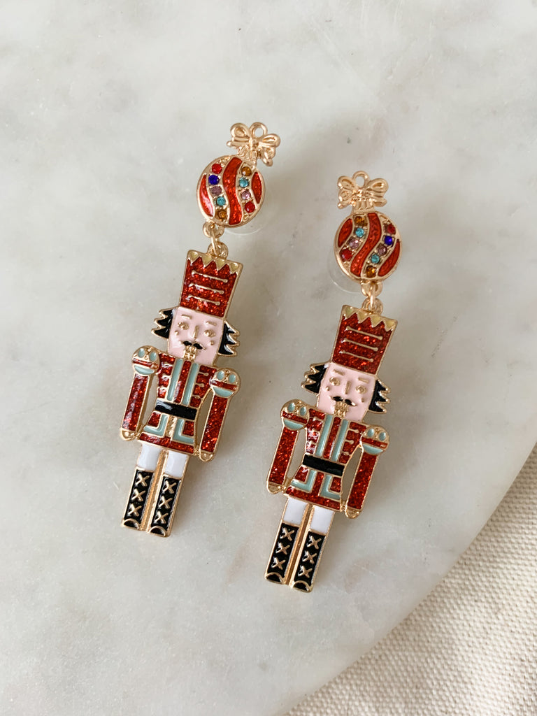 Enjoy the spirit of the holiday season with these festive Glitter Nutcracker Christmas Dangle Earrings! These glittery earrings will sparkle and shine throughout every party. With a unique enamel and glitter details, this style with stand out. They are fun and make a great gift too!