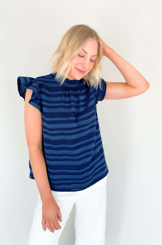 Look your best in our Good Days Ruffle Sleeveless Textured Top! With round neckline and striped texture, your days will be sunshine and rainbows, even when the atmosphere's a little grey. The fabric is elevated and comfortable, perfect for life's events. Choose from mustard, ivory, and navy to find your perfect color – no matter the forecast!