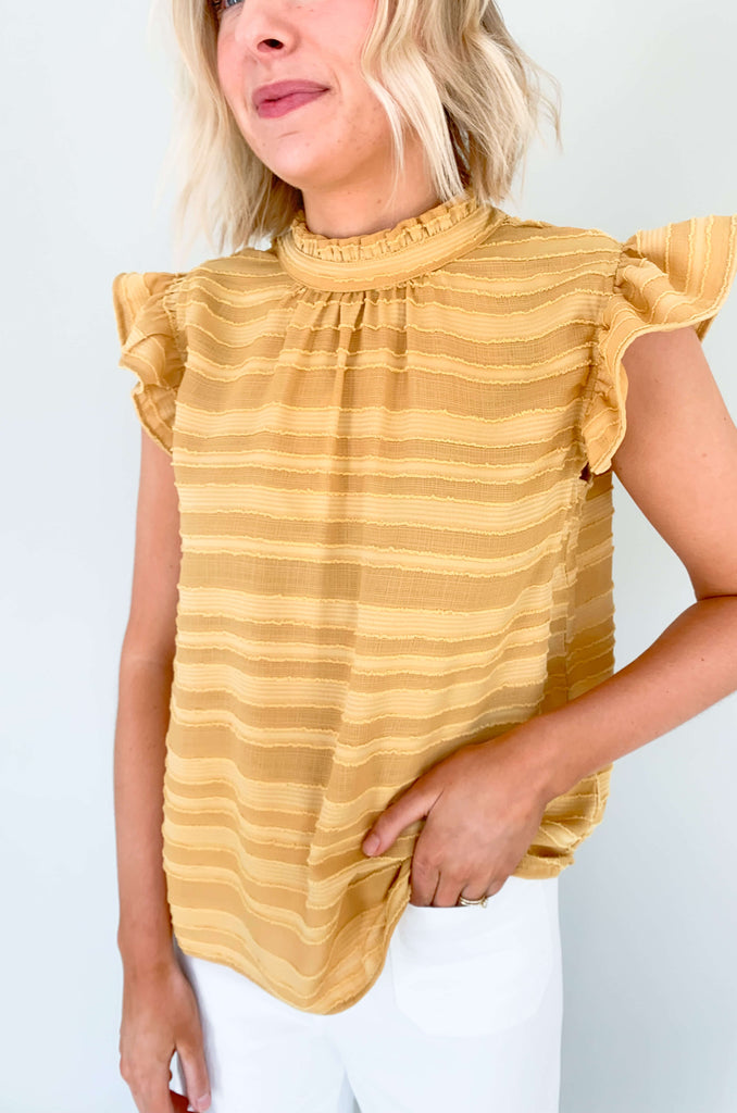 Look your best in our Good Days Ruffle Sleeveless Textured Top! With round neckline and striped texture, your days will be sunshine and rainbows, even when the atmosphere's a little grey. The fabric is elevated and comfortable, perfect for life's events. Choose from mustard, ivory, and navy to find your perfect color – no matter the forecast!