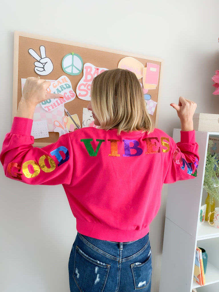 Cropped sequin pullover that says " GOOD VIBES ONLY". Cropped with a stretchy waistband and same material on the wrist. Available in Fuchsia or heather Gray in size small-large