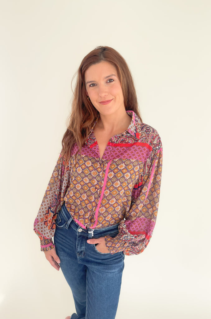 This Hot Pink & Red Boho Long Sleeve Blouse has a lightweight sheer material and features a stylish collar and cinched wrists for a sleek work look! The stylish print features pops of red, magenta, mustard, and green.