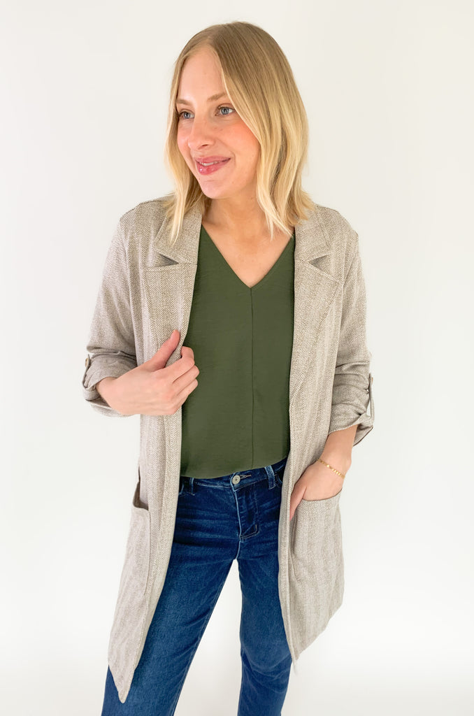 This Hutch Herringbone Roll Tab Coat is perfect for any occasion! It features a natural herringbone fabric with button detailing on the cuffs and side pockets for extra convenience. 