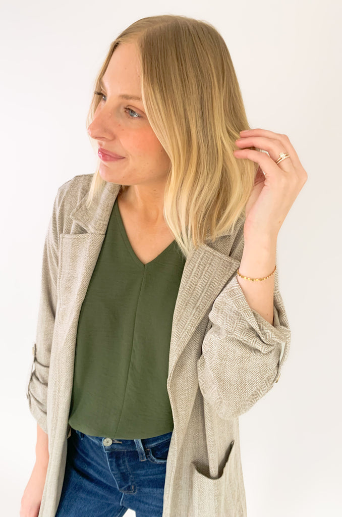 This Hutch Herringbone Roll Tab Coat is perfect for any occasion! It features a natural herringbone fabric with button detailing on the cuffs and side pockets for extra convenience. 