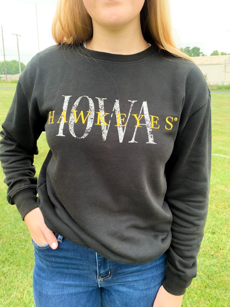 The IOWA Brooks Bock Fleece Crewneck is perfect for hawkeyes fans! Its black fleece and yellow embroidered "Hawkeyes" and printed "IOWA" create a stylish statement. Aside from being perfect for game day, it's also extremely soft and cozy. Show your school spirit with this high-quality crewneck for this fall, or gift one to your favorite Iowa Alum.