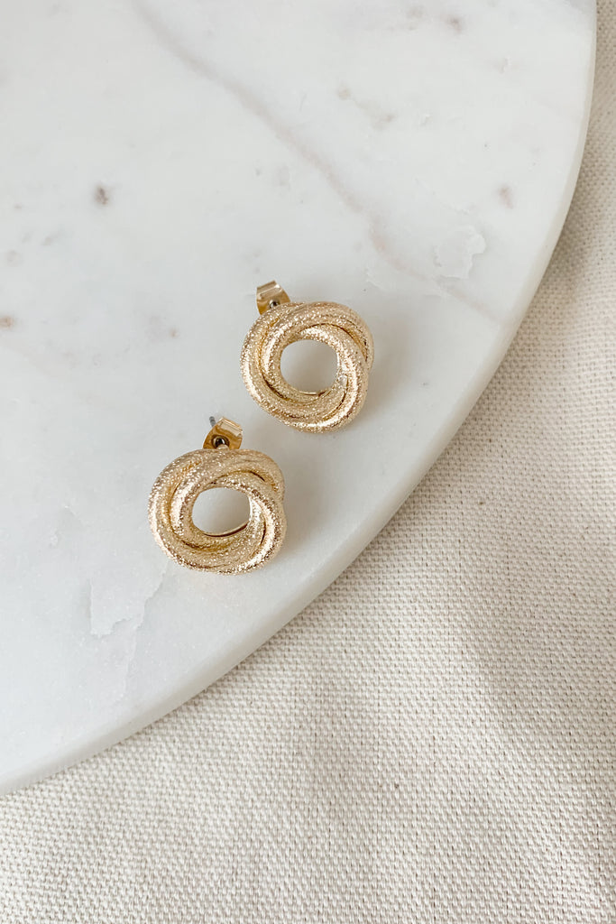 The Interlocked Circle Post Earrings make a subtle statement with their reflective gold design. There are micro indentations for texture and shipper, creating a gorgeous earring. The interlocked circle design is unique too. This stud is a great option for dressing up any look!