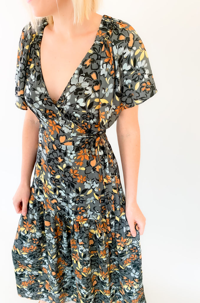 Maxi dress with a v-neckline. With a wrap dress that ties and has a beautiful floral print with gray, orange, light blue, and yellow coloring!