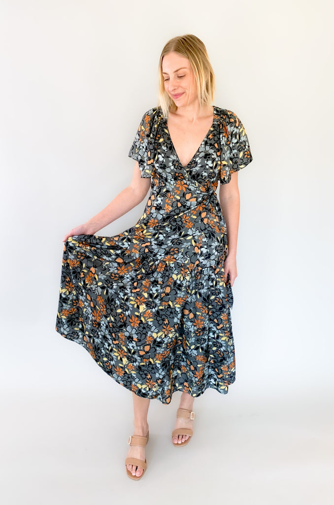 Maxi dress with a v-neckline. With a wrap dress that ties and has a beautiful floral print with gray, orange, light blue, and yellow coloring!