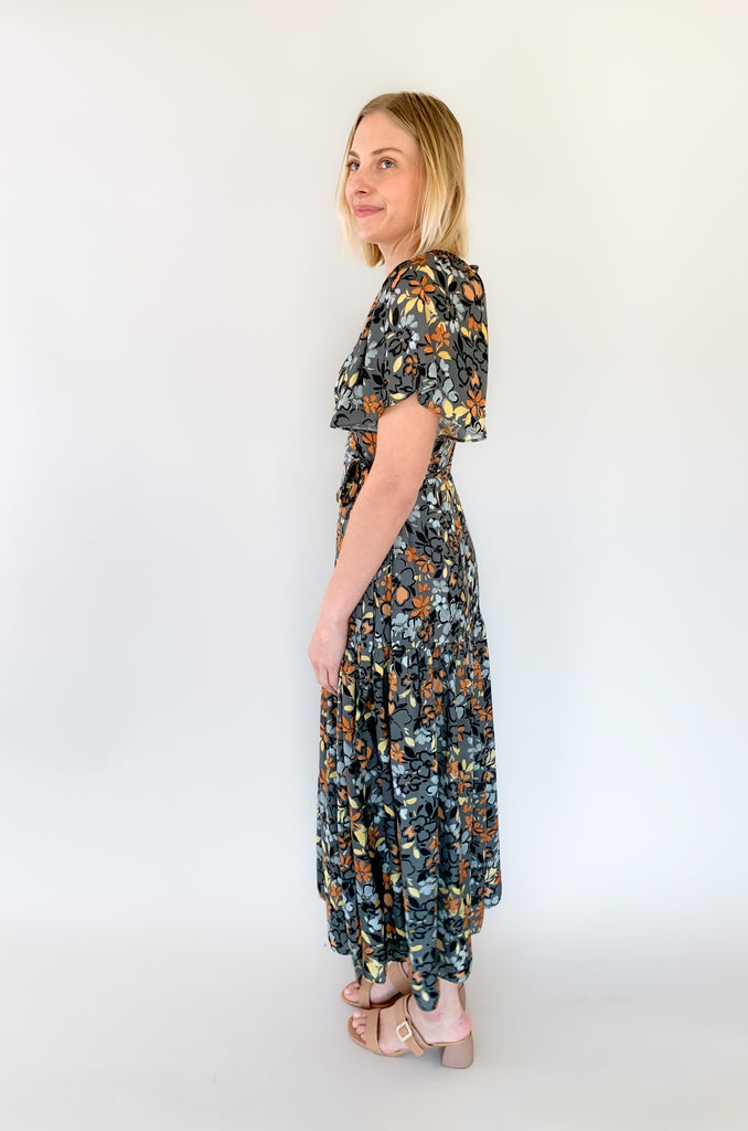 Maxi dress with a v-neckline. With a wrap dress that ties and has a beautiful floral print with gray, orange, light blue, and yellow coloring!