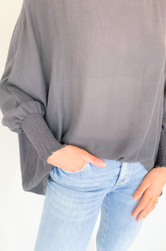 The Joel Smocked Dolman Sleeve Oversized Top is perfect for the breezy summer days. Made of a lightweight and airy fabric, it allows for a cute and comfortable fit. This top features long sleeves and a smocked wrist for an effortless, chic look. With its oversized style, it’s easy to layer or wear alone.