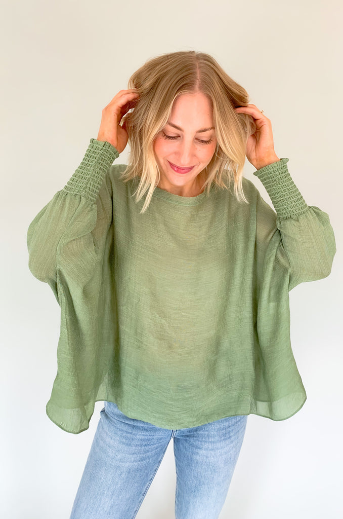 The Joel Smocked Dolman Sleeve Oversized Top is perfect for the breezy summer days. Made of a lightweight and airy fabric, it allows for a cute and comfortable fit. This top features long sleeves and a smocked wrist for an effortless, chic look. With its oversized style, it’s easy to layer or wear alone.