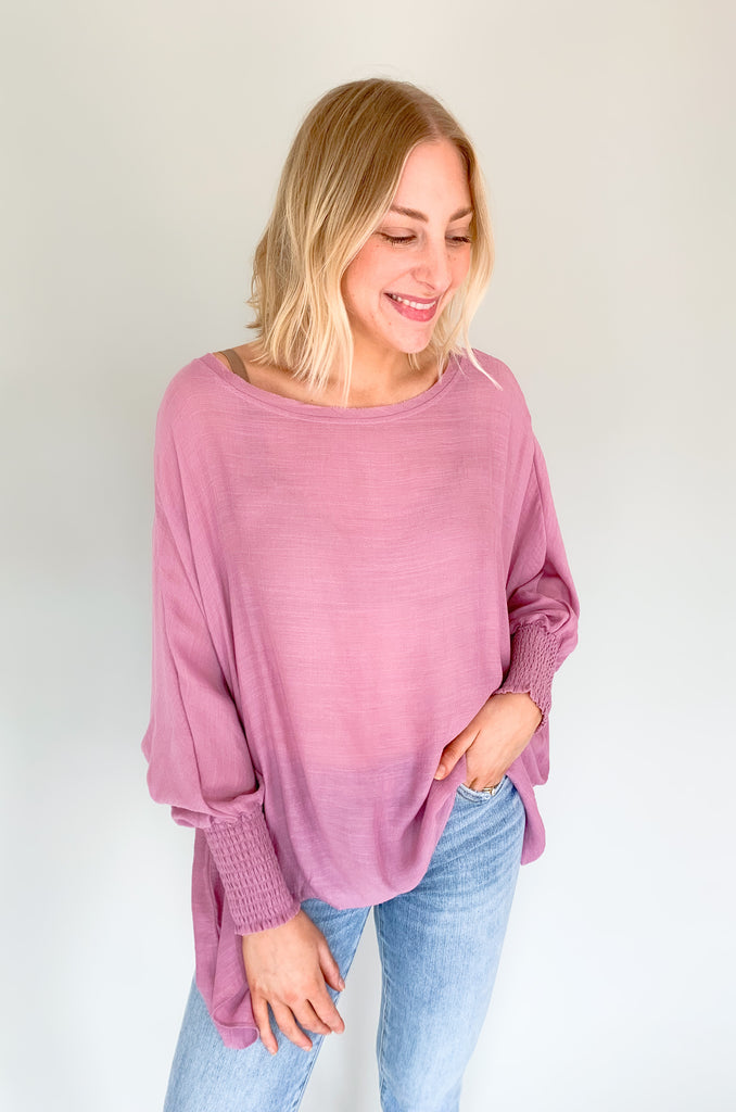 The Joel Smocked Dolman Sleeve Oversized Top is perfect for the breezy summer days. Made of a lightweight and airy fabric, it allows for a cute and comfortable fit. This top features long sleeves and a smocked wrist for an effortless, chic look. With its oversized style, it’s easy to layer or wear alone.