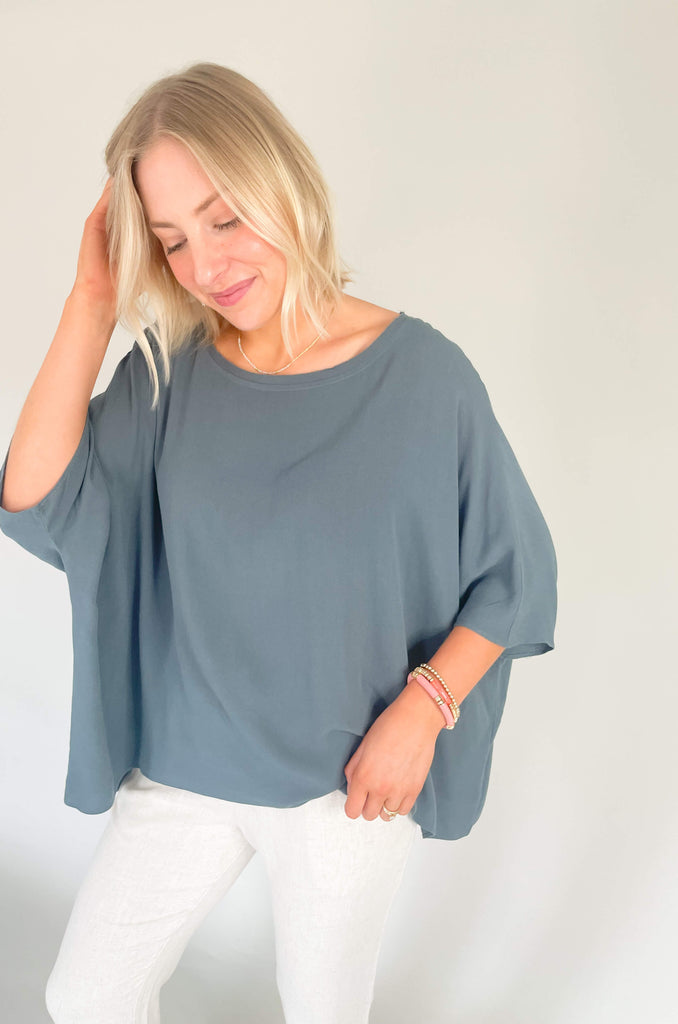 Introducing the Johnna Solid Oversized Top that's here to keep you lookin' cool and feeling comfortable all summer! This lightweight round neck boxy top is airy and effortless, but can easily be dressed up for any occassion. Choose between steel blue or sand for an amazing everyday look. 