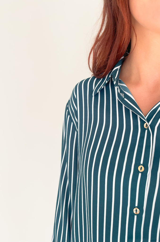 lightweight, semi sheer striped blouse with collared details and gold buttons. Available in pin striped black or hunter green
