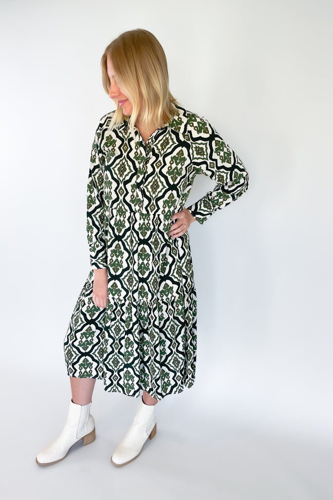 The Macy Olive Printed Midi Dress is the perfect way to elevate your wardrobe! This stylish piece has a button-up top with collared details and long sleeves, plus a tiered body for a flattering shape. It reads very boho chic. 