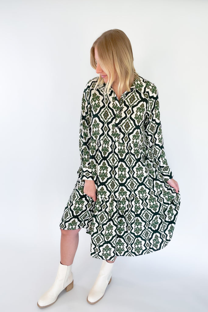 The Macy Olive Printed Midi Dress is the perfect way to elevate your wardrobe! This stylish piece has a button-up top with collared details and long sleeves, plus a tiered body for a flattering shape. It reads very boho chic. 
