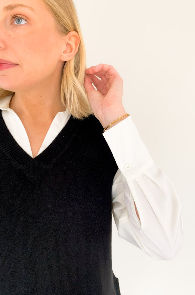 Stay stylish when the weather cools down with the Elan Geist Black Sweater Vest & Layered Blouse! This unique one-piece is made of knit fabric to keep you warm and comfortable, while featuring a flattering satin blouse underneath.