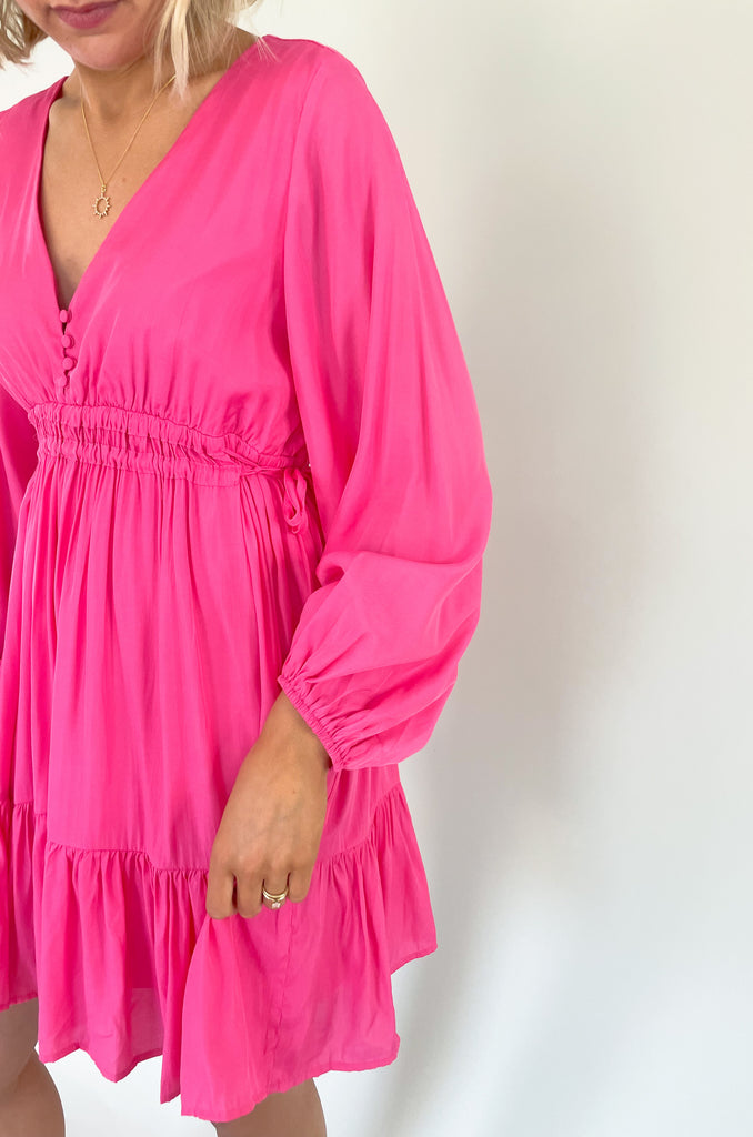 This Pinky Elastic Waistband V Neck Dress is perfect for a dinner date or special event. The baby doll shaped v neck provides a flirty and unique look while the tiered bottom adds a fun flounce. We are loving the elastic waist. It provide comfort and confidence with a great silhouette. 