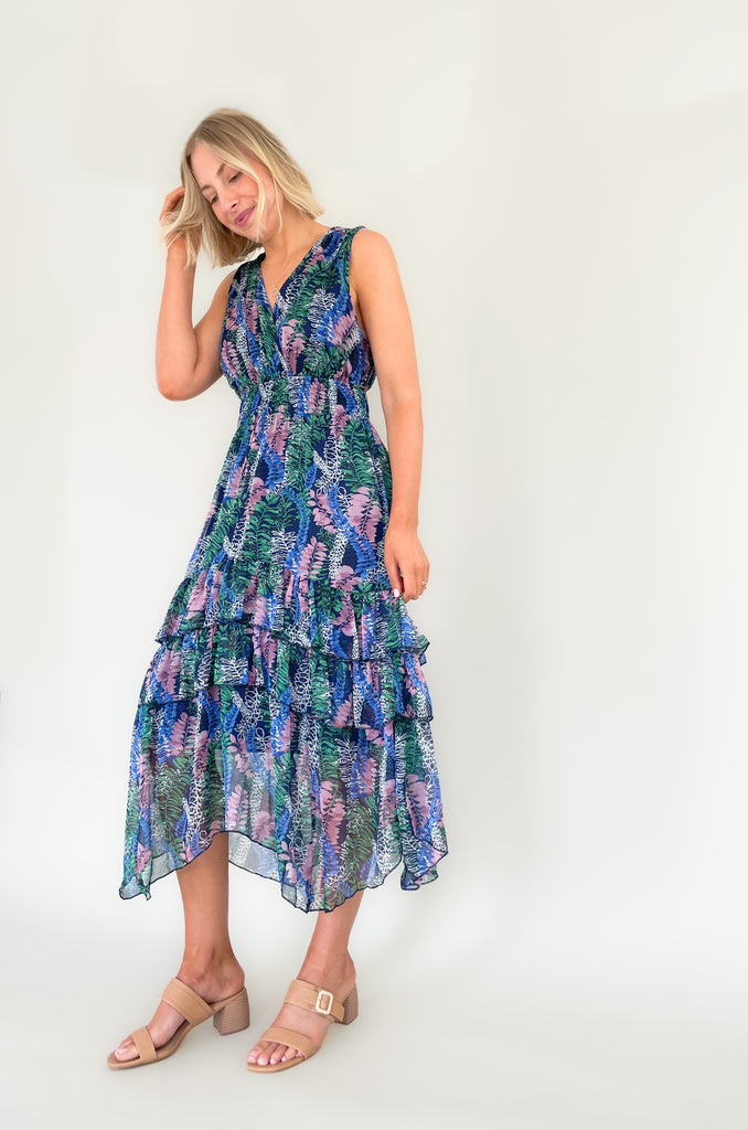 Relax and remain stylish in the Rainforest Ruffle Maxi Dress. This v neck dress features a wide strap with a tiered body that is made of a beautiful mix of blues, purples and greens. Its relaxed fit and lightweight material make it the perfect maxi dress for summer days. 