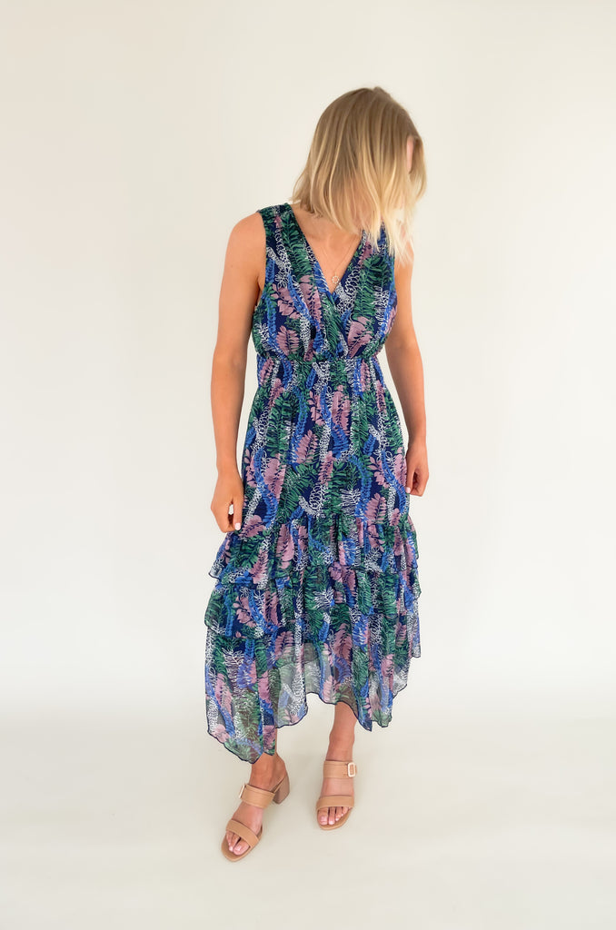 Relax and remain stylish in the Rainforest Ruffle Maxi Dress. This v neck dress features a wide strap with a tiered body that is made of a beautiful mix of blues, purples and greens. Its relaxed fit and lightweight material make it the perfect maxi dress for summer days. 