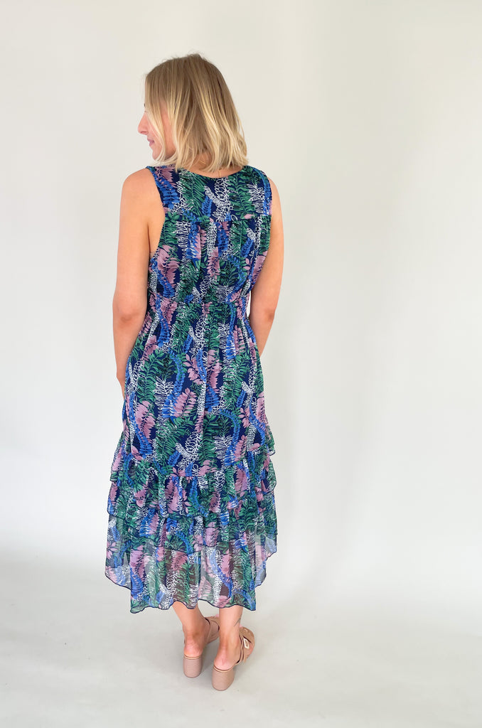 Relax and remain stylish in the Rainforest Ruffle Maxi Dress. This v neck dress features a wide strap with a tiered body that is made of a beautiful mix of blues, purples and greens. Its relaxed fit and lightweight material make it the perfect maxi dress for summer days. 