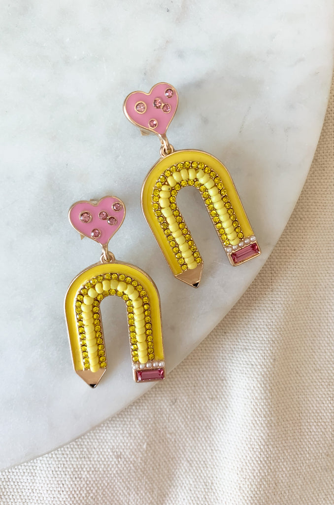 The Rhinestone & Beaded Yellow Arch Pencil Earrings are so adorable and fun! They play into the creative energy of a bright classroom. Plus, the bead and rhinestone details add a little sparkle and ship. They are metal with enamel, lightweight, and perfect for back to school!