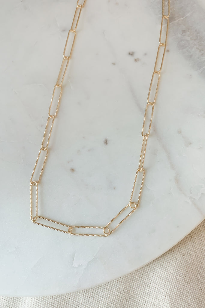 The Ribbed Paperclip Gold Necklace has so much sparkle and shine while remaining timeless. You cannot go wrong with a paperclip style necklace. It adds an elevated touch to any look. This necklace is 15" with a 3" extender. 