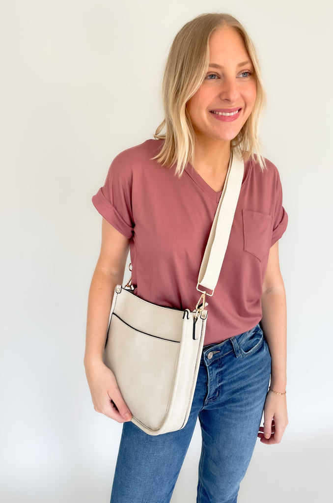 The Rosie Faux Leather Crossbody is a staple handbag! This faux leather bag has a soft a durable feel! There is a detachable, tonal, and adjustable strap that comes with the Rosie, or an Adjustable Fabric Guitar Strap is also available! Both options are so cute! This handbag is the smaller version of one of our best sellers, the Chloe Faux Leather Handbag with Guitar Strap. 