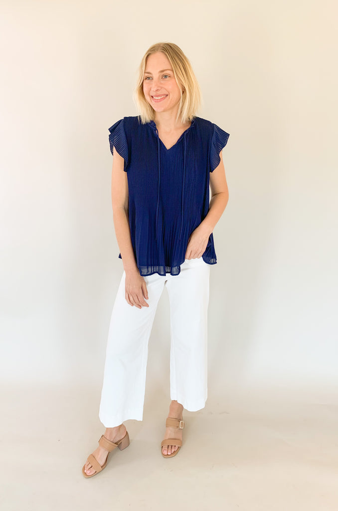 Navy short sleeve pleated blouse with a airy pleated top layer and a navy underlay. V-neck with a tie detailing