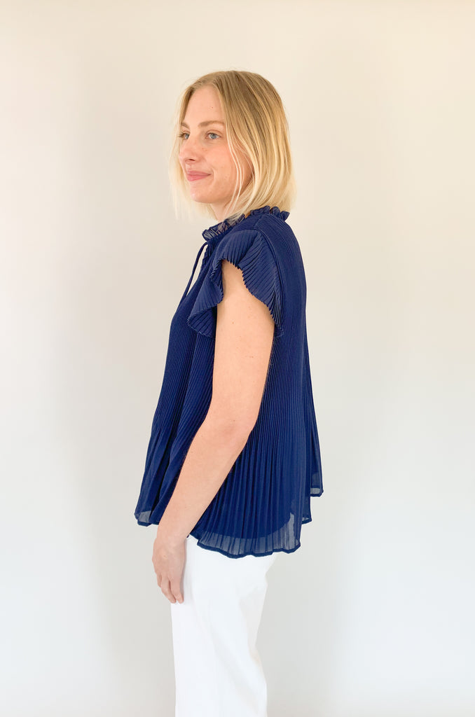 Navy short sleeve pleated blouse with a airy pleated top layer and a navy underlay. V-neck with a tie detailing