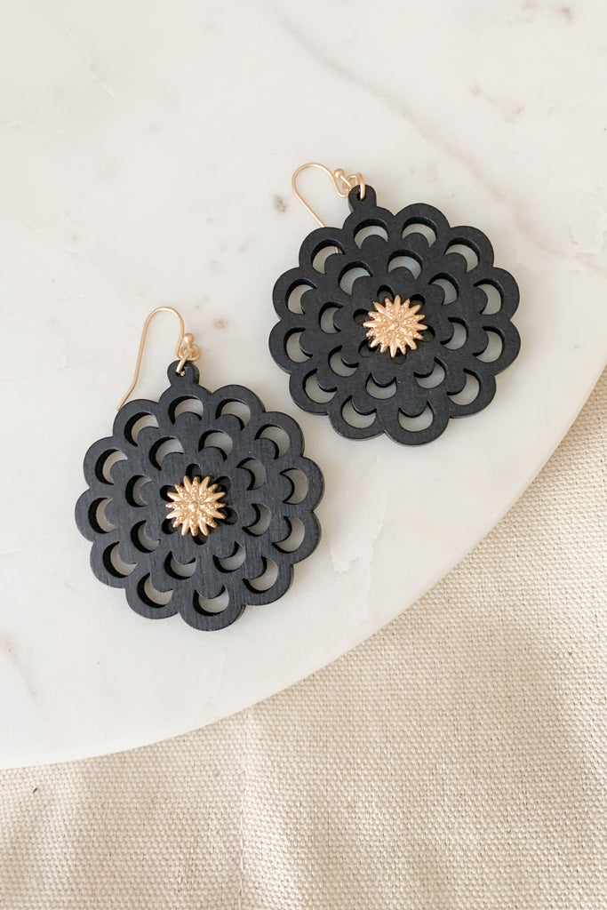 The Scalloped Wood Black Flower Earrings are playful and boho. They make a statement with their intricate wooden design. We are loving the gold touches too. Because the drop design is made from wood, these earrings are very lightweight.