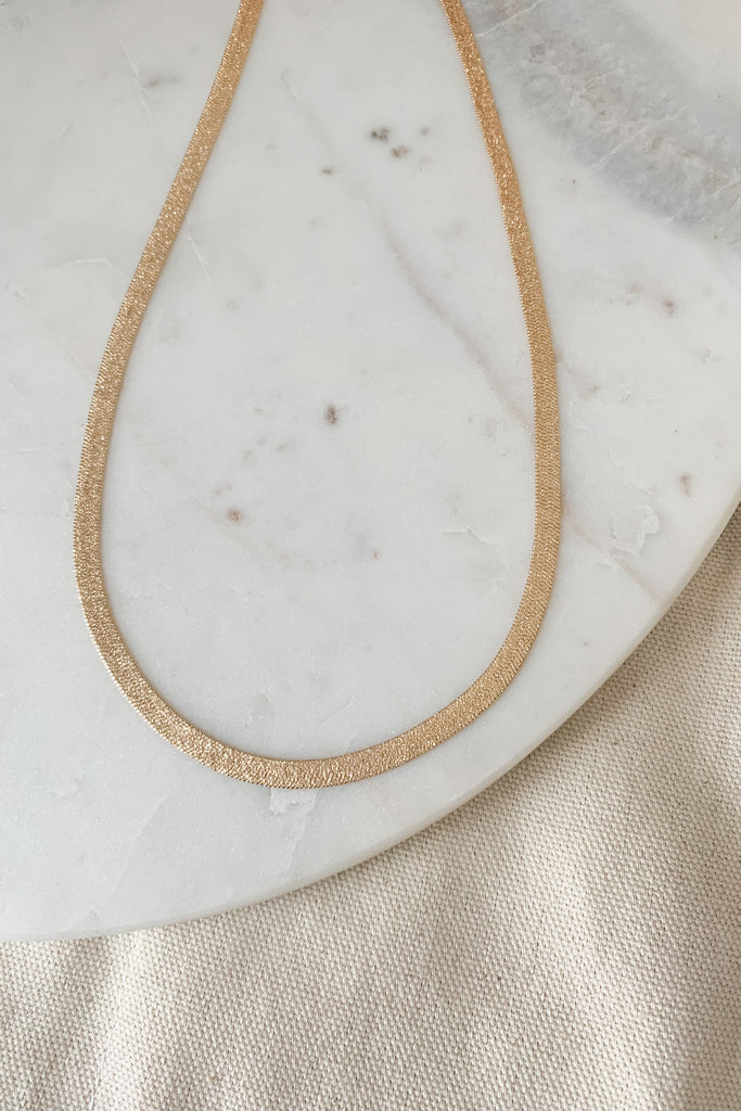 The Shimmer Snake Chain Necklace is a stylish piece! Crafted with a unique shimmer, this necklace will add a touch of sparkle to any look. Its chain length is 16" with a 3" extender. 
