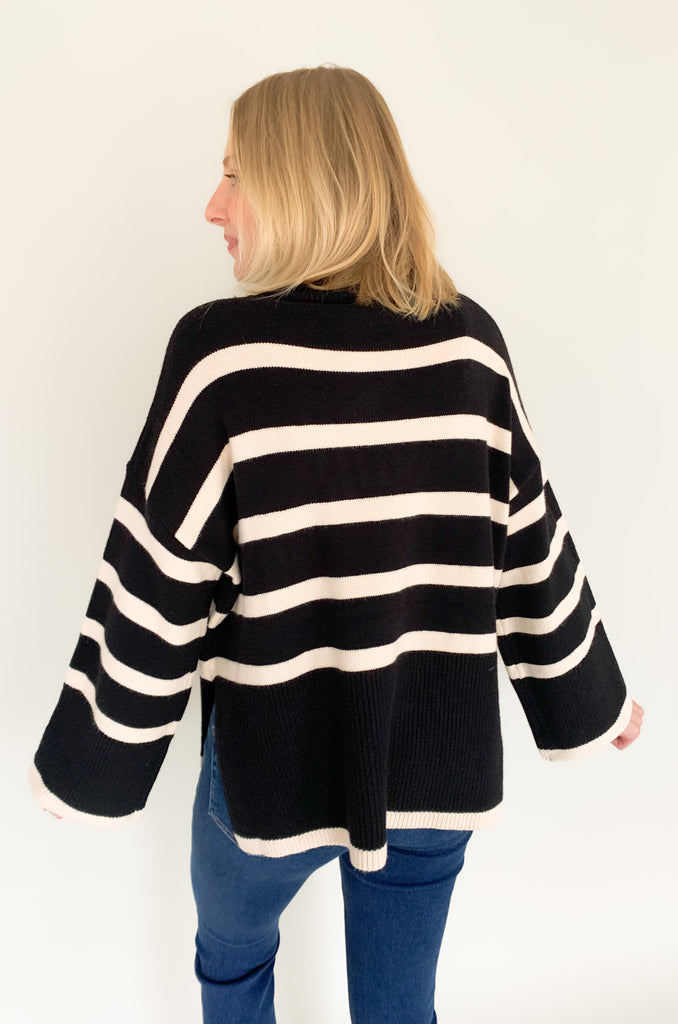 Striped pink or black turtleneck with wide sleeves, flowy body, and side slits in a comfortable knit fabric