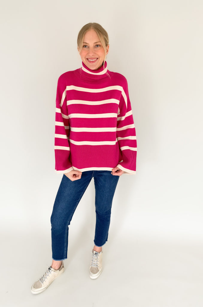 Striped pink or black turtleneck with wide sleeves, flowy body, and side slits in a comfortable knit fabric